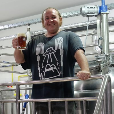 Andreas Hartfiel Head Brewer smiling with a glass of beer
